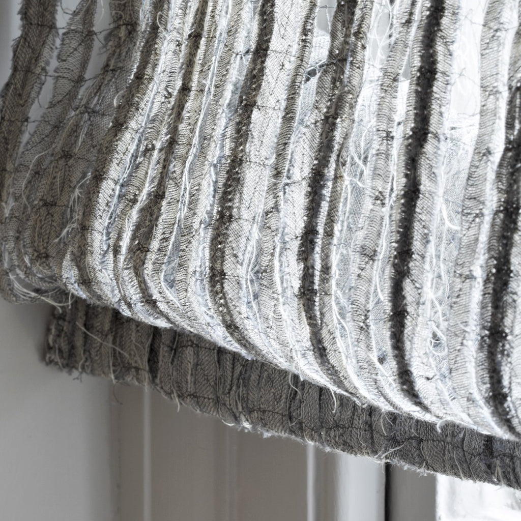 Close-up of textured fabric with horizontal stripes on a neutral background